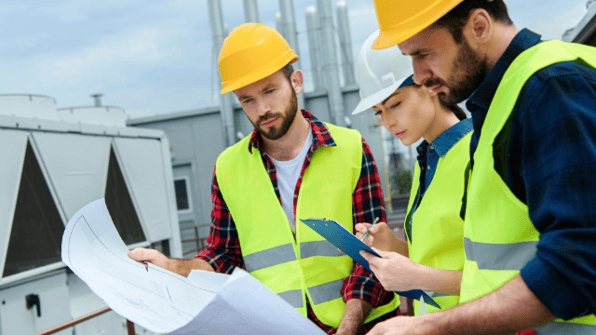 Construction workers discussing plans on site